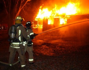 Firefighters Use Hose at Hillside Road Fire