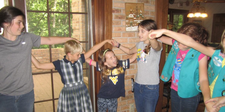 Left to right, Cadette Georgia Gunter (Troop 69), Daisy, Chloe Gunter (Troop 22107) with Junior Girl Scouts, Ahna Wurm (Troop 20492) and Daphne and Becca Seay (Troop 20509) learn the "weave" for singing "Weave Us Together." (Submitted photo)