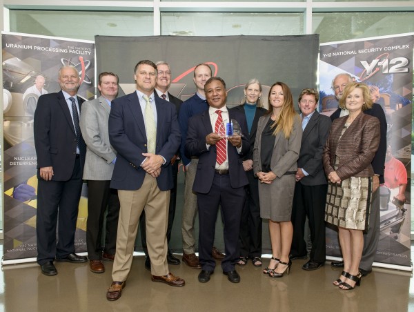 GEM Technologies Inc. was recently honored as a small business of the year by Consolidated Nuclear Security LLC. Shown in the photo are CNS Supply Chain Manager Skip Skelton, CNS Vice President and Y-12 Site Manager Bill Tindal, CNS Subcontract Administrator Aaron Hughes, GEM (guy in the back with glasses) Chief Financial Officer Ben Jerrell, GEM Business Development Brad Wicks, GEM, GEM President and Chief Executive Officer Michael Evans, GEMTech Nuclear Security Solutions Contract Manager Lisa Stinton, GEM Vice President Engineering & Technical Services Ryan Overton, CNS Vice President of Mission Assurance Linda Bauer, CNS Vice President of Operations Support Darrell Graddy, and CNS Program Manager for Socioeconomic Programs Lisa Copeland. (Photo by CNS Y-12)