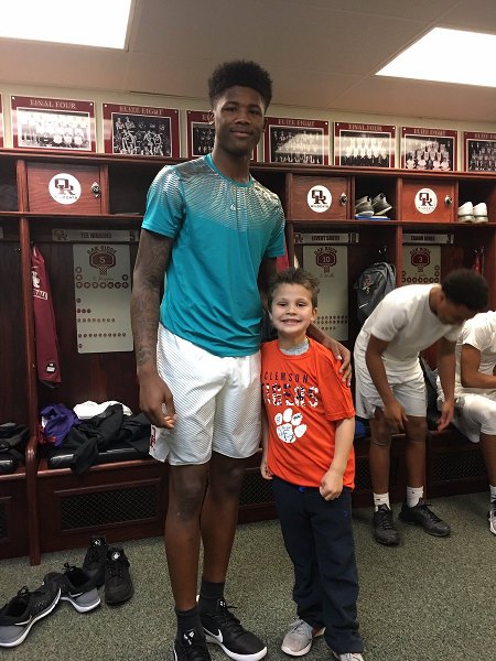 AJ Cucksey, a six-year-old cancer survivor and kindergarten student at Farragut Primary, meets Oak Ridge Wildcats senior Tee Higgins, who dunked for AJ during a 68-38 win over West during a Region 2-AAA quarterfinal game at Wildcats Arena on Saturday, Feb. 25, 2017. (Photo courtesy Stephanie Thompson)
