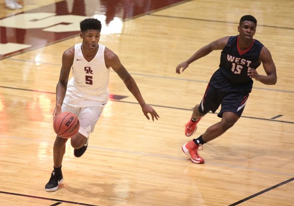 Oak Ridge senior Tee Higgins (5) dribbles the basketball in transition against West sophomore Jawaun Moore (15) during a 68-38 Region 2-AAA quarterfinal win for the Wildcats at home on Saturday, Feb. 25, 2017. (Photo by Luther Simmons)