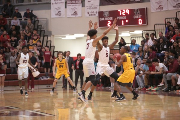 Oak Ridge seniors Talion Jones (3) and Tee Higgins (5) trap John Releford (4) of David Crockett during a 90-60 win for the Wildcats in a Class AAA sectional at Wildcat Arena on Monday, March 6, 2017. (Photo by Luther Simmons)