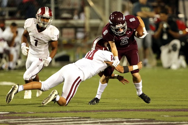 Above, Oak Ridge junior defensive back Shemar Smith (14) makes a tackle at Dobyns-Bennett in Kingsport on Friday, Aug. 25, 2017. Also pictured is junior linebacker Jeremy Mitchell (1). (Photo by Allen Greene Photography)