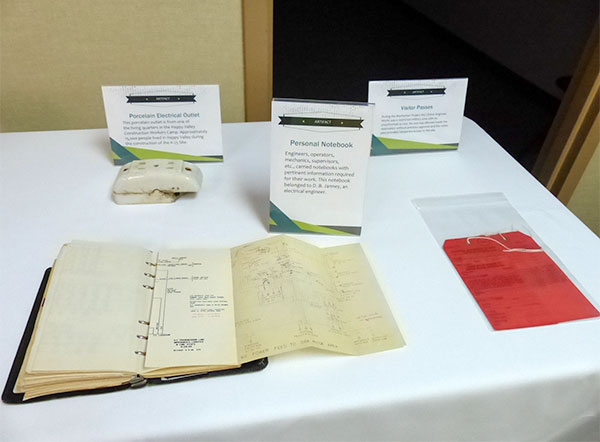 Artifacts pictured above at the K-25 History Center on Thursday, Oct. 19, 2017, are a porcelain electrical outlet, a personal notebook, and visitor passes. (Photo by John Huotari/Oak Ridge Today)