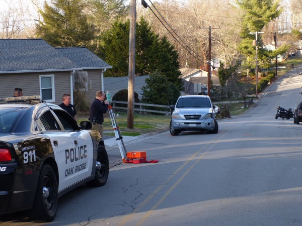 The Oak Ridge Police Department investigates a crash between a Kia and a motorcycle that seriously injured a motorcyclist between California Avenue and Ogden Drive on Wednesday, Feb. 21, 2018. Looking through the device used in crash reconstruction is Oak Ridge Police Department Detective Kevin Craig. Behind him is ORPD Officer Matthew Johnston. (Photo by John Huotari/Oak Ridge Today)